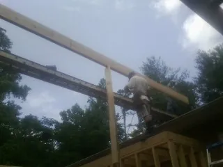 Carpenter setting a ridge beam over a new addition frame — Ice Dam Removal by Roofing Brothers in Gaines