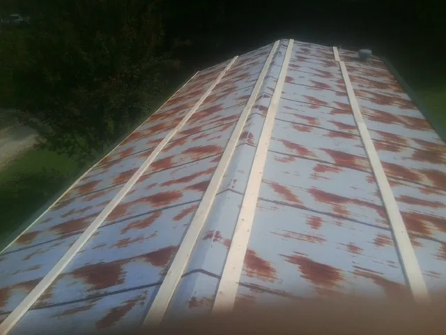 Rusted metal roof panels with new wood purlins before replacement — Storm Damage Roof Repair in Gaines by Roofing Brothers