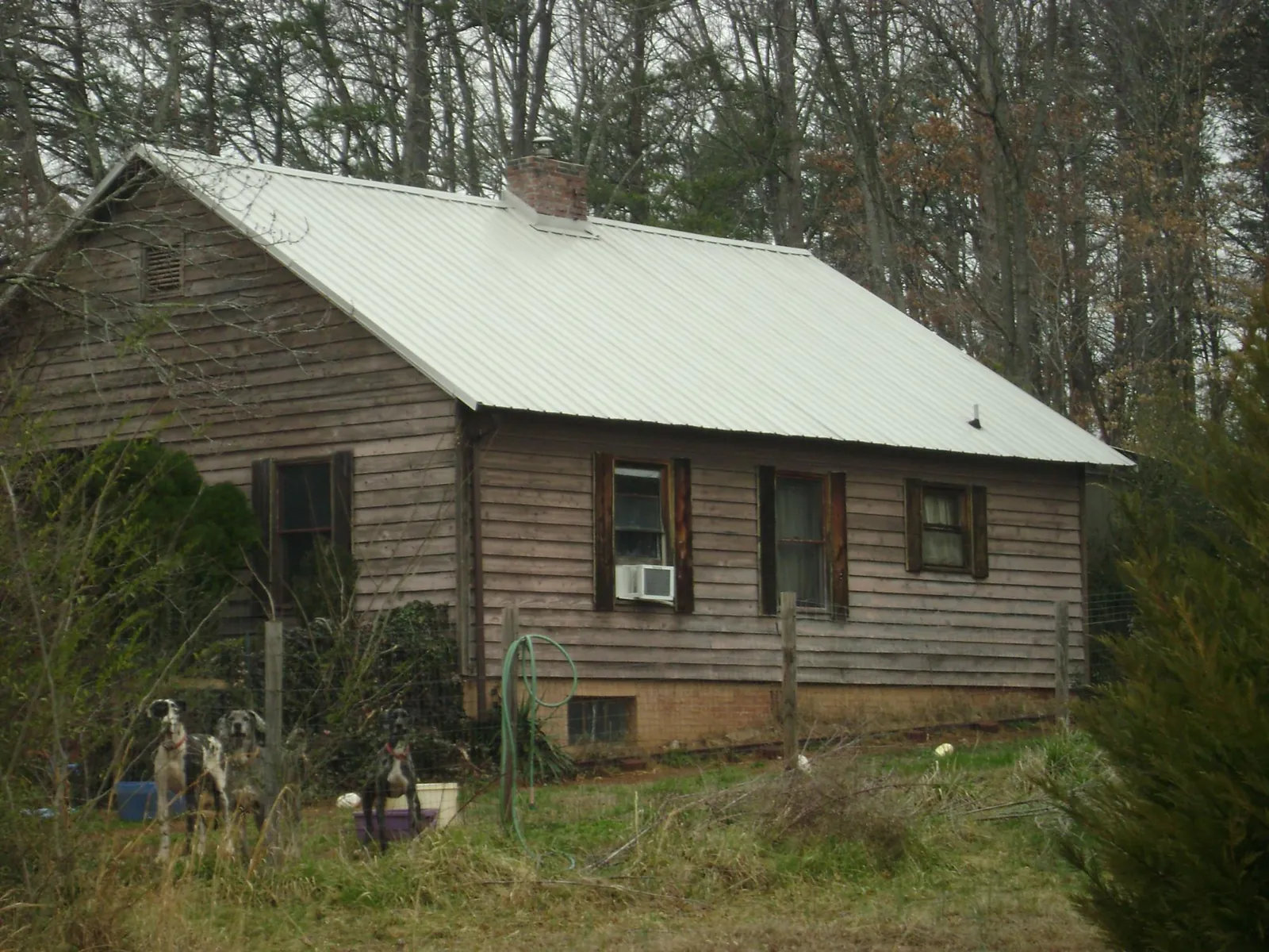 White metal roof on an old wood sided farmhouse, from a Metal Roof Installation job in Gaines